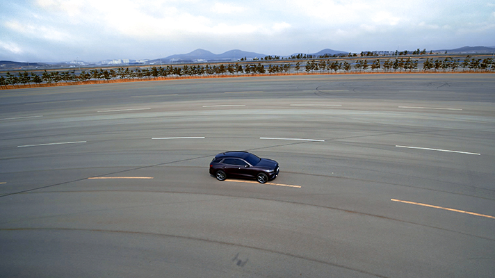 Side view of the Genesis GV70 on a driving test track