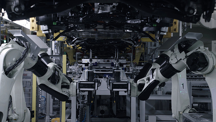 로봇이 비전 센서와 볼트 고정장치를 이용해 배터리를 고정하는 모습