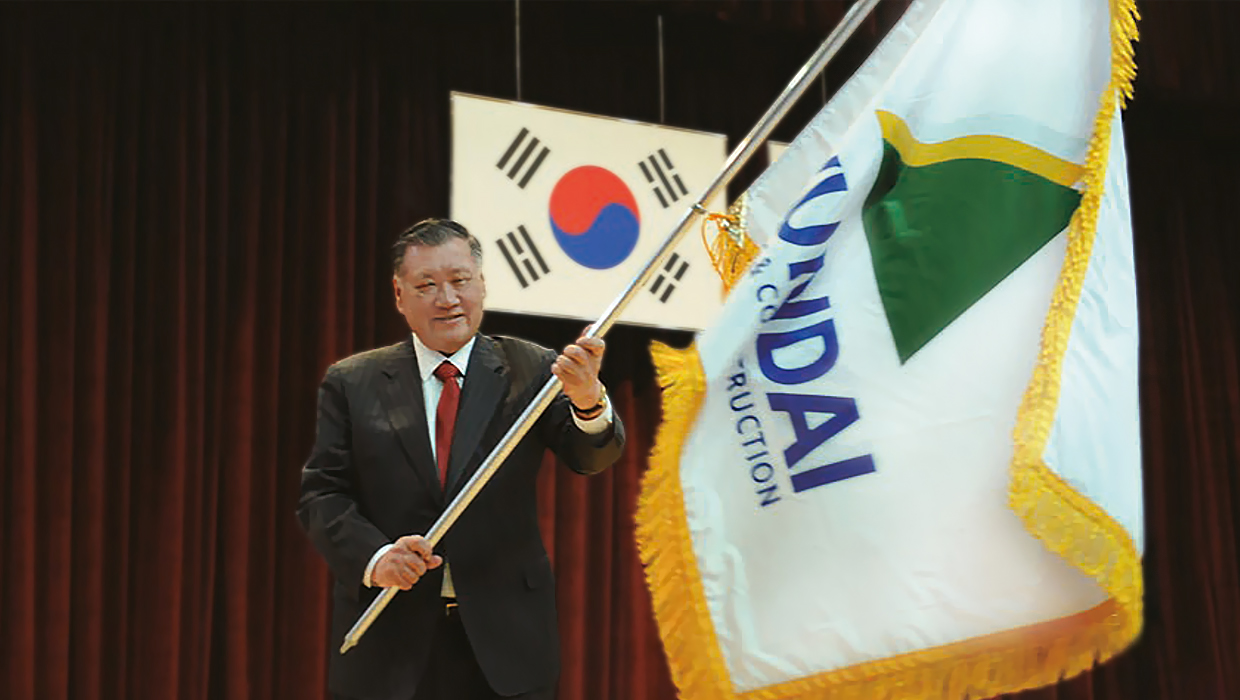 Chairman Chung Mong-koo waving a flag with the Hyundai E&C logo on it