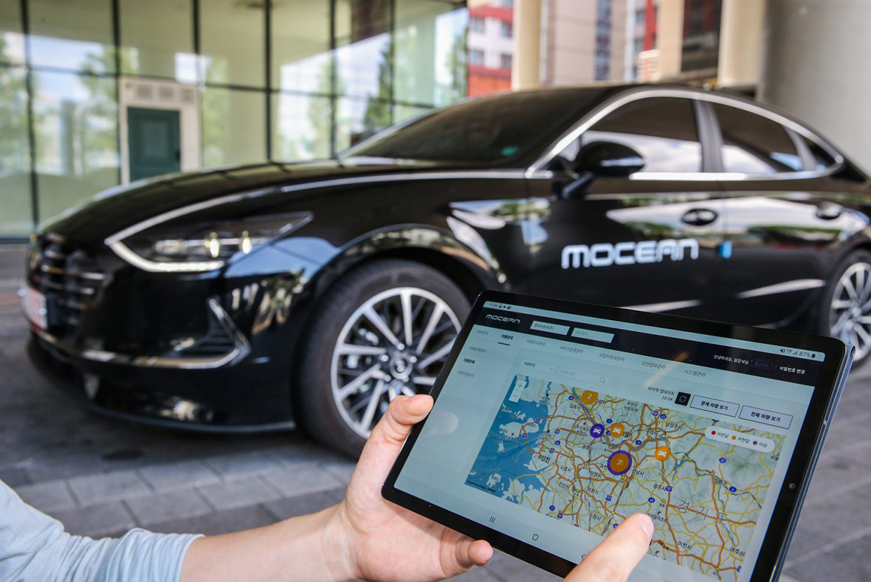 Person looking at screen of MOCEAN as Car Sharing
