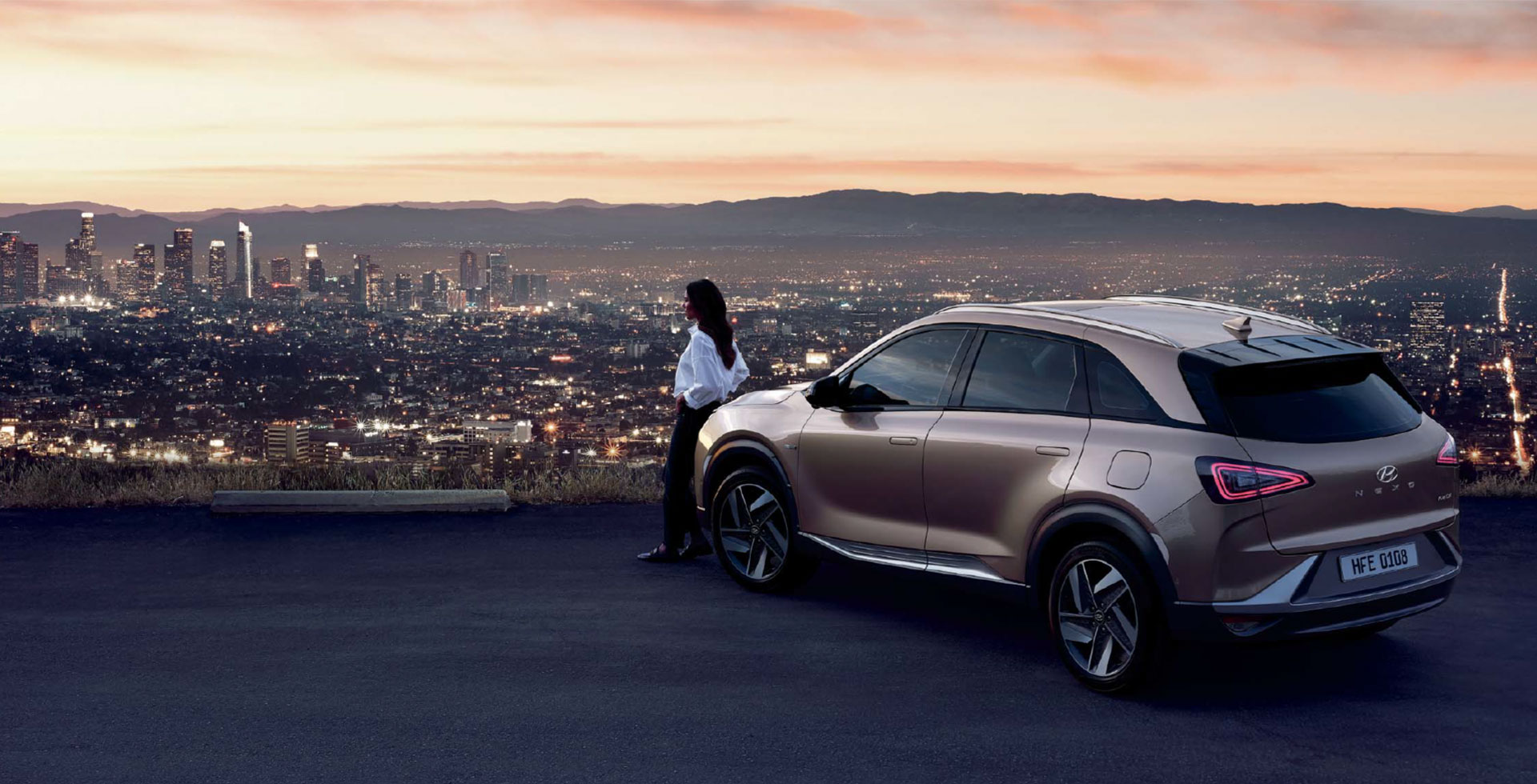 NEXO 좌측 후면 뷰와 도시 풍경을 바라보는 사람 모습