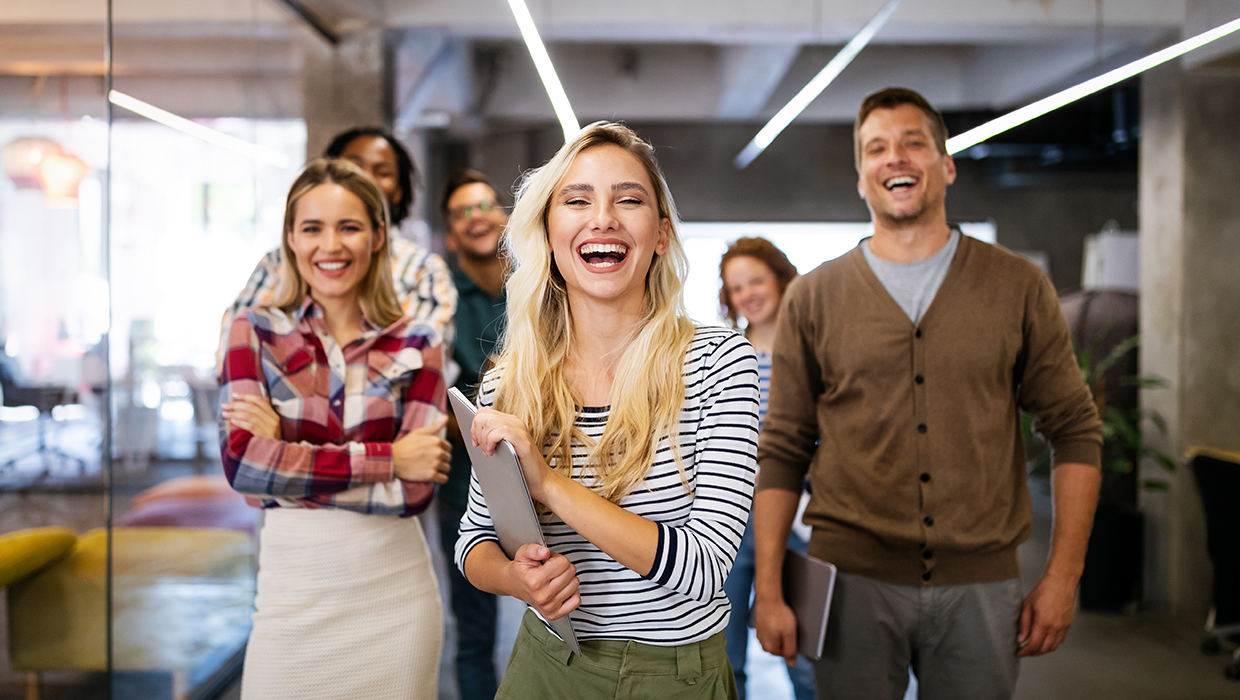 Multiracial workers looking straight ahead and smiling broadly