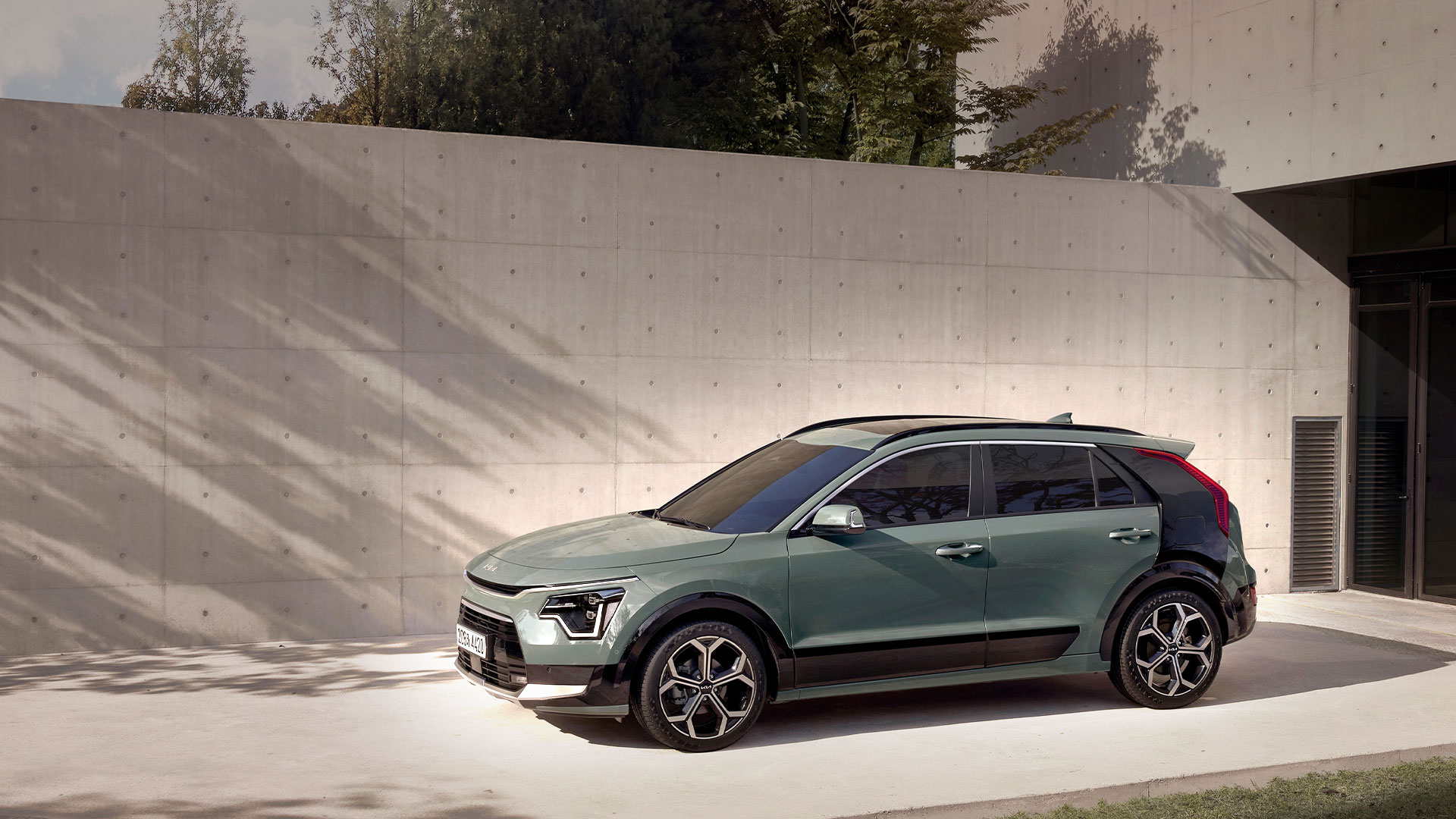 The all-new Kia Niro standing in front of the architecture of wood tone