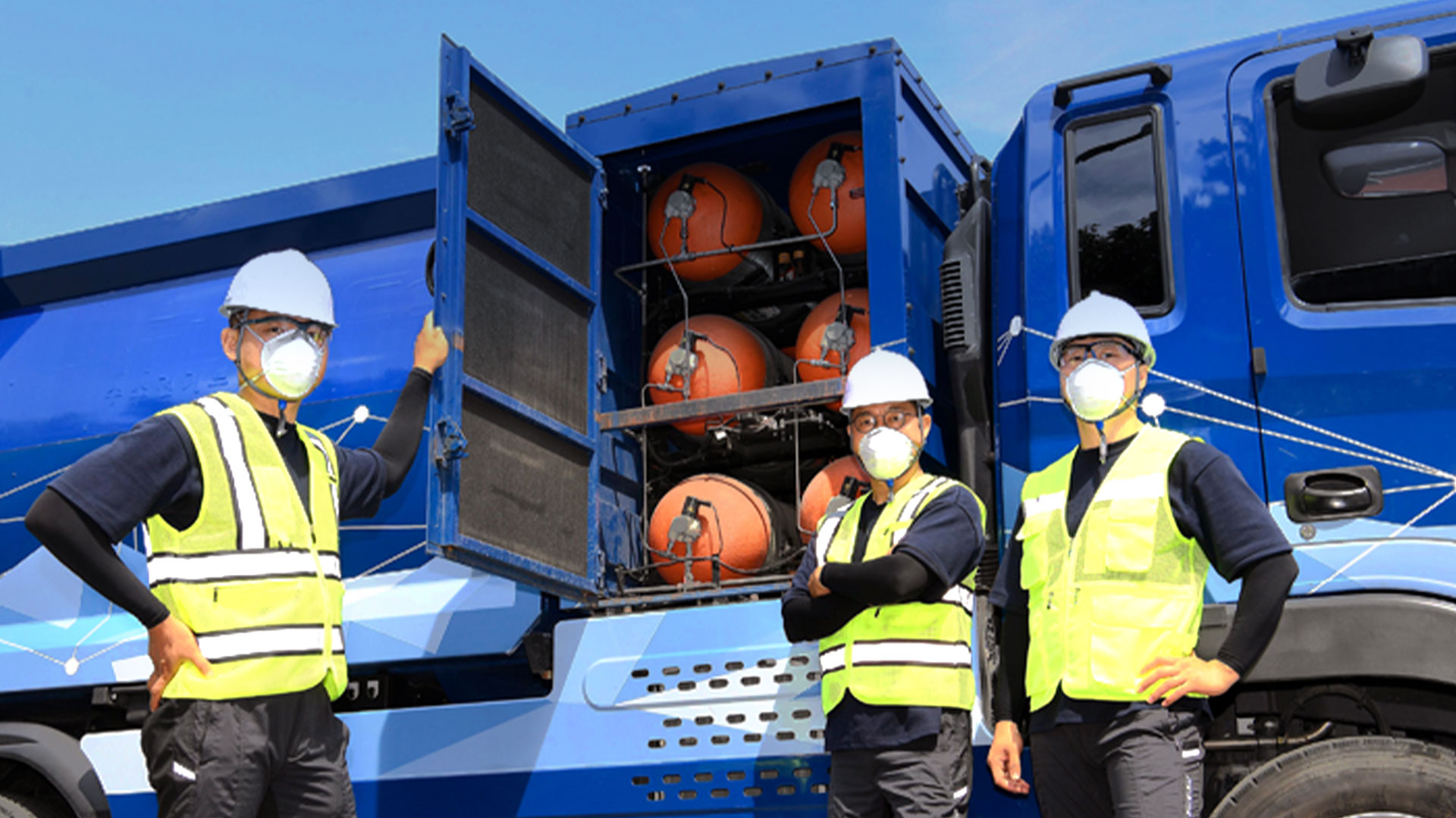 수소청소트럭 앞에 서 있는 세 명의 환경미화원