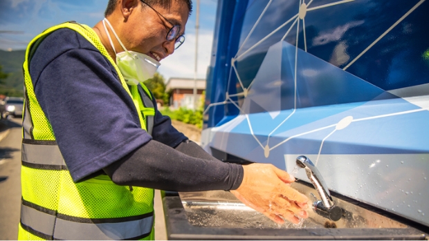 수소청소트럭의 배출수로 손을 씻는 환경미화원