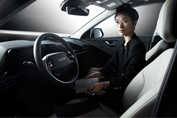 Jang Su-jin, a senior researcher sitting in Niro's passenger seat explaining the interior color and material