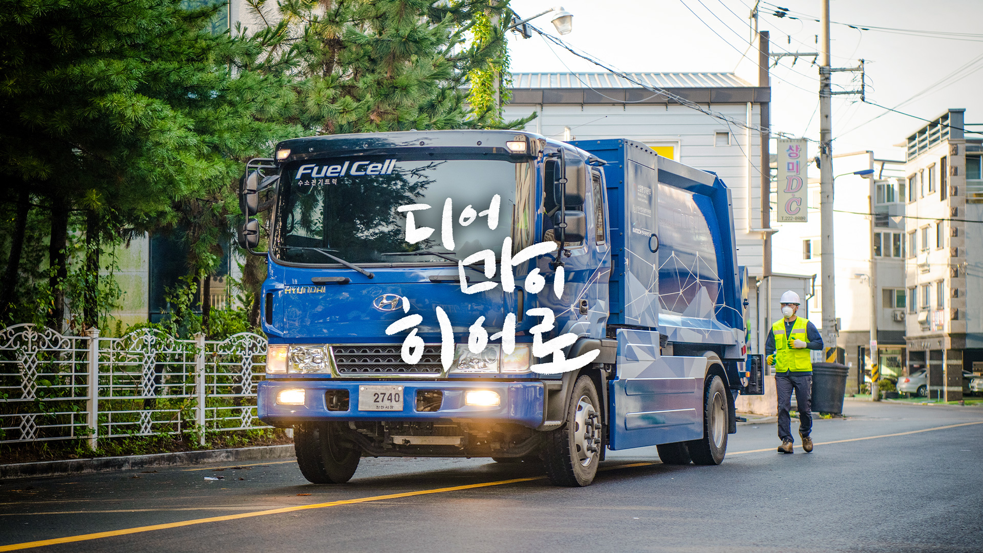 운행 중인 수소청소트럭과 그 뒤를 따라 달리고 있는 환경미화원의 모습을 배경으로 한 디어 마이 히어로 타이틀 사진