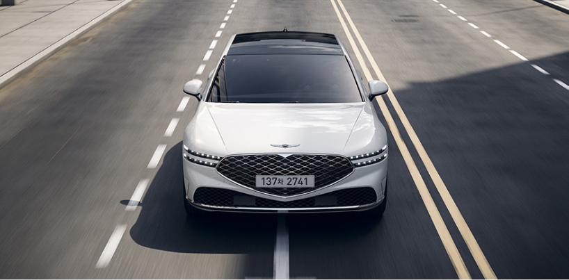 Genesis G90 with Uyuni white color driving on the road