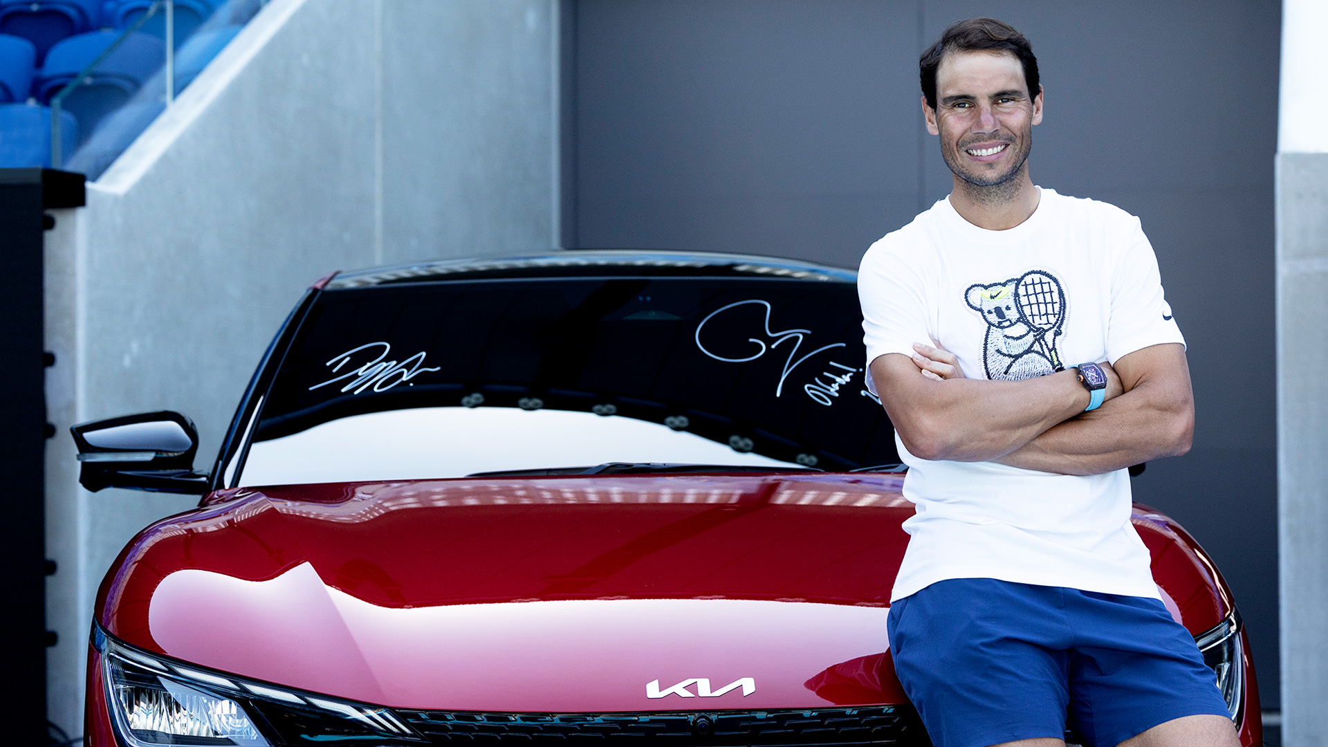 라파엘 나달 선수가 기아의 첫 전용 전기차 EV6 후드에 걸터 앉아 웃고 있다