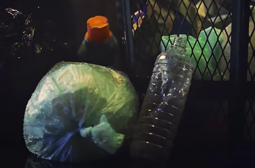 Next to the trash can is a plastic bottle that looks like a plastic bottle used as a water bottle and a detergent container