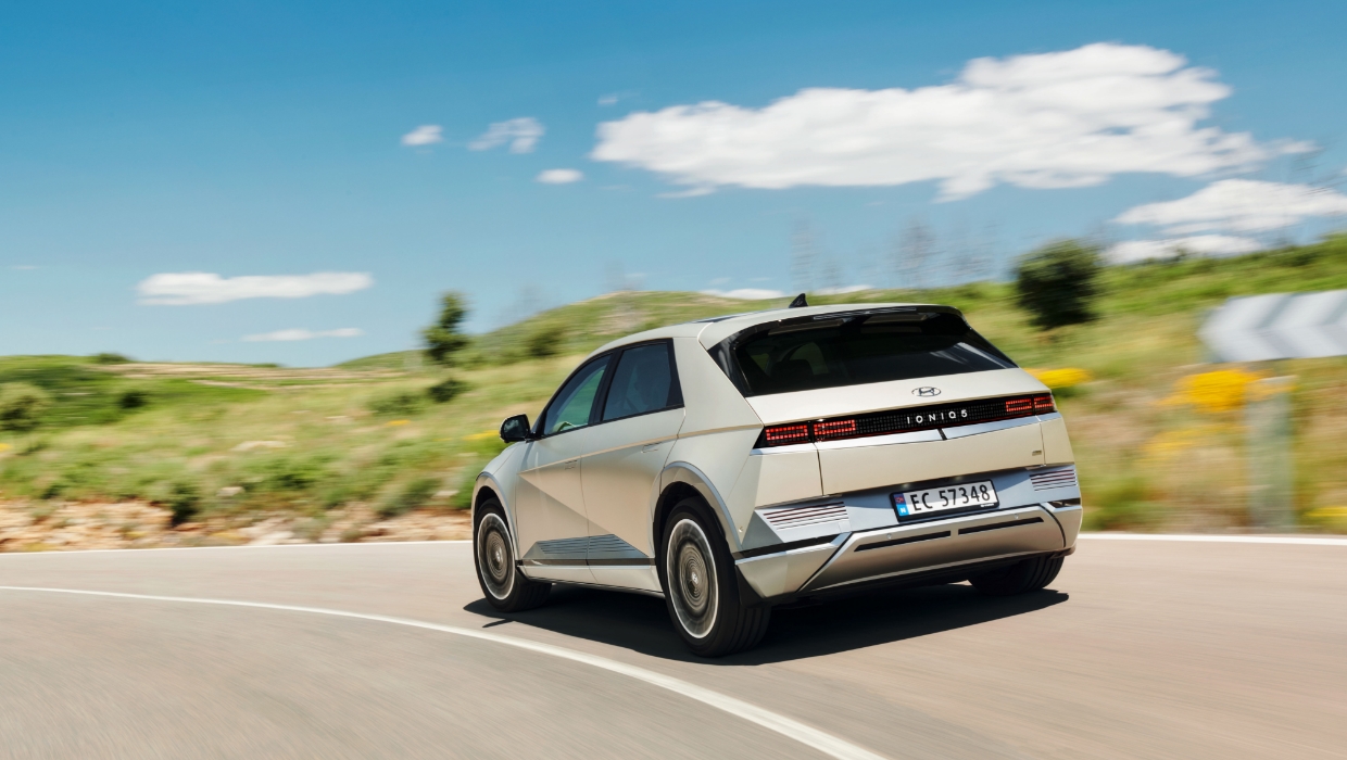 The rear side of Ioniq 5 driving on a rural road in Europe