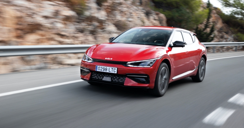 유럽의 어느 시골 길을 달리고 있는 EV6의 정측면 모습