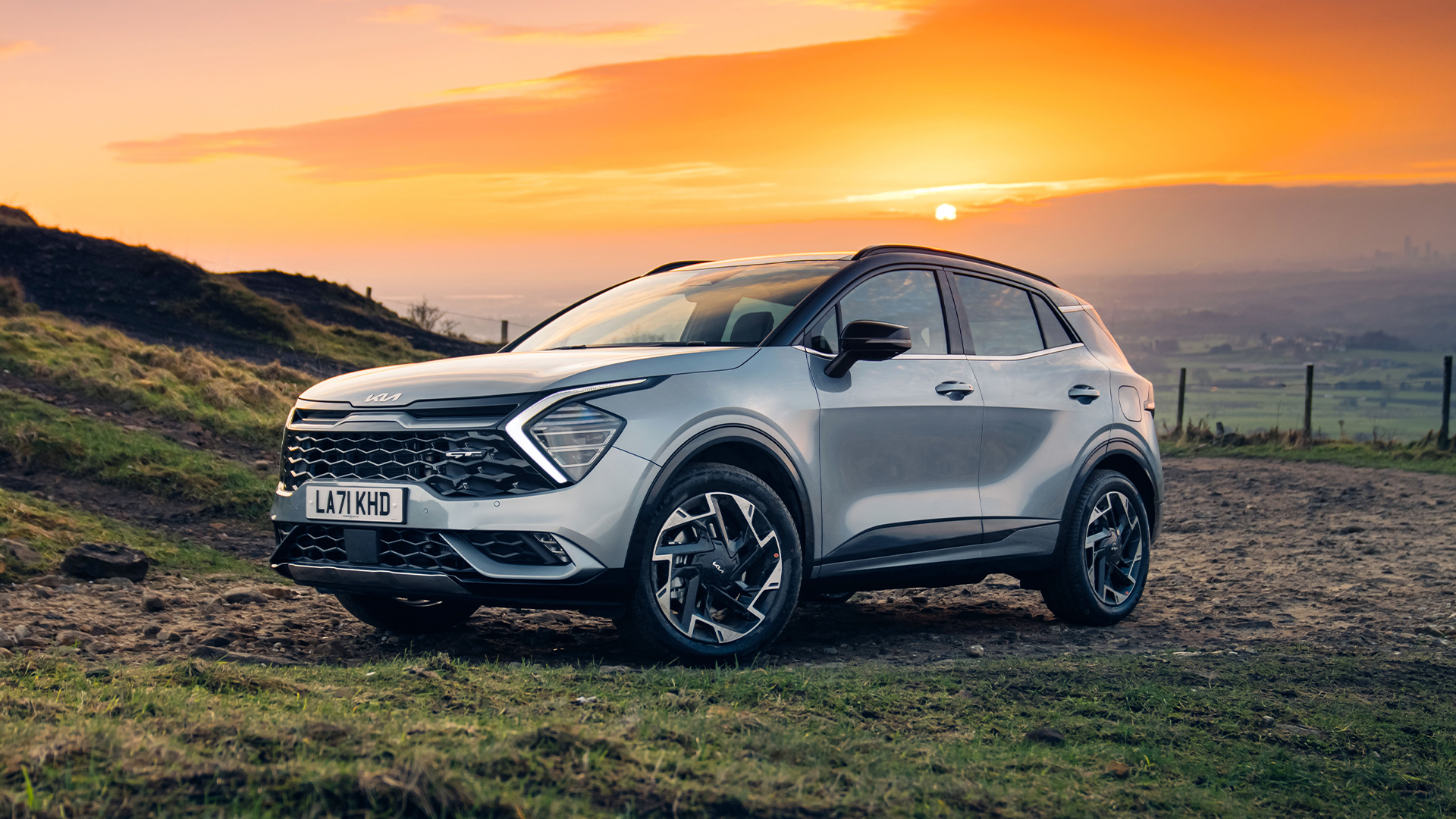 석양을 배경으로 서있는 스포티지의 정측면