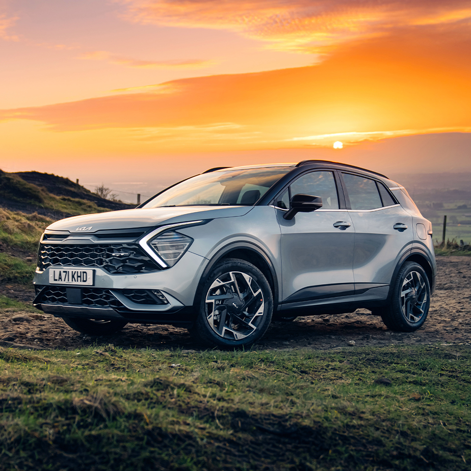 석양을 배경으로 서있는 스포티지의 정측면