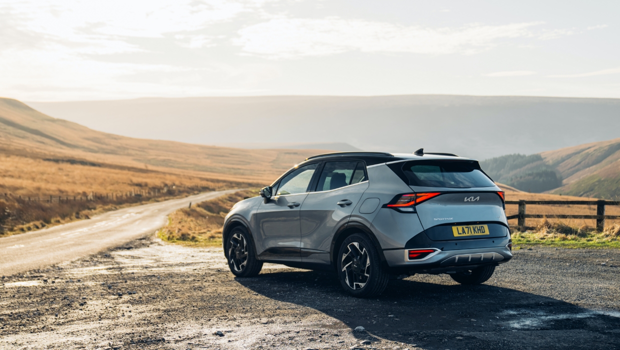 기아 스포티지가 멋진 자연을 배경으로 서 있는 뒷모습