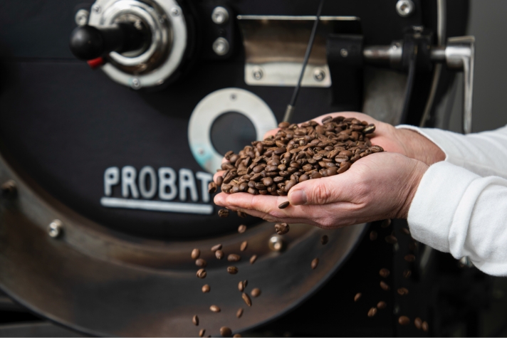 원두 기계 앞에서 양 손바닥 가득 원두를 올려놓고 있는 장우영 씨의 모습