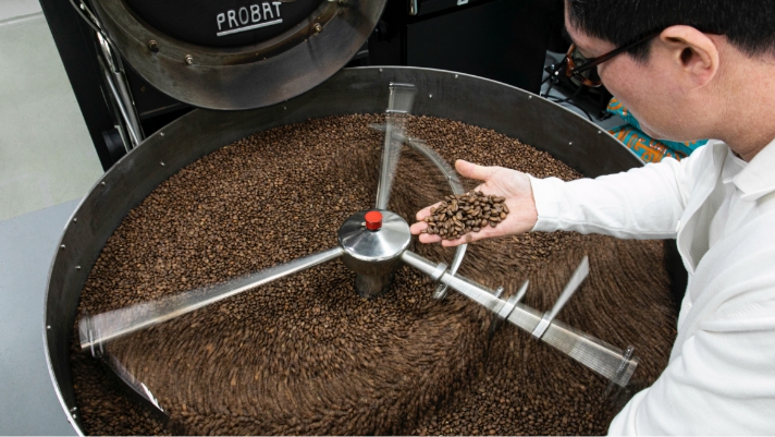 로스팅 기계에서 볶아지고 있는 원두를 살펴보는 장우영 씨의 모습