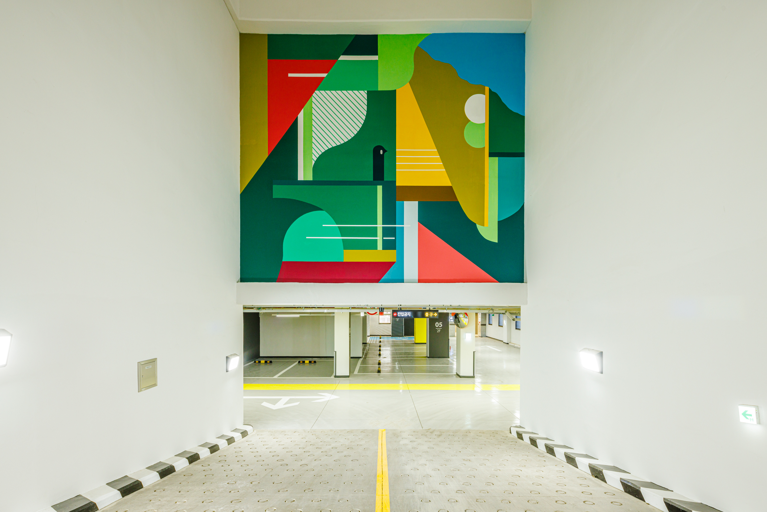 A colorful art wall in collaboration with Junkhouse is installed on the wall in front of the underground parking lot