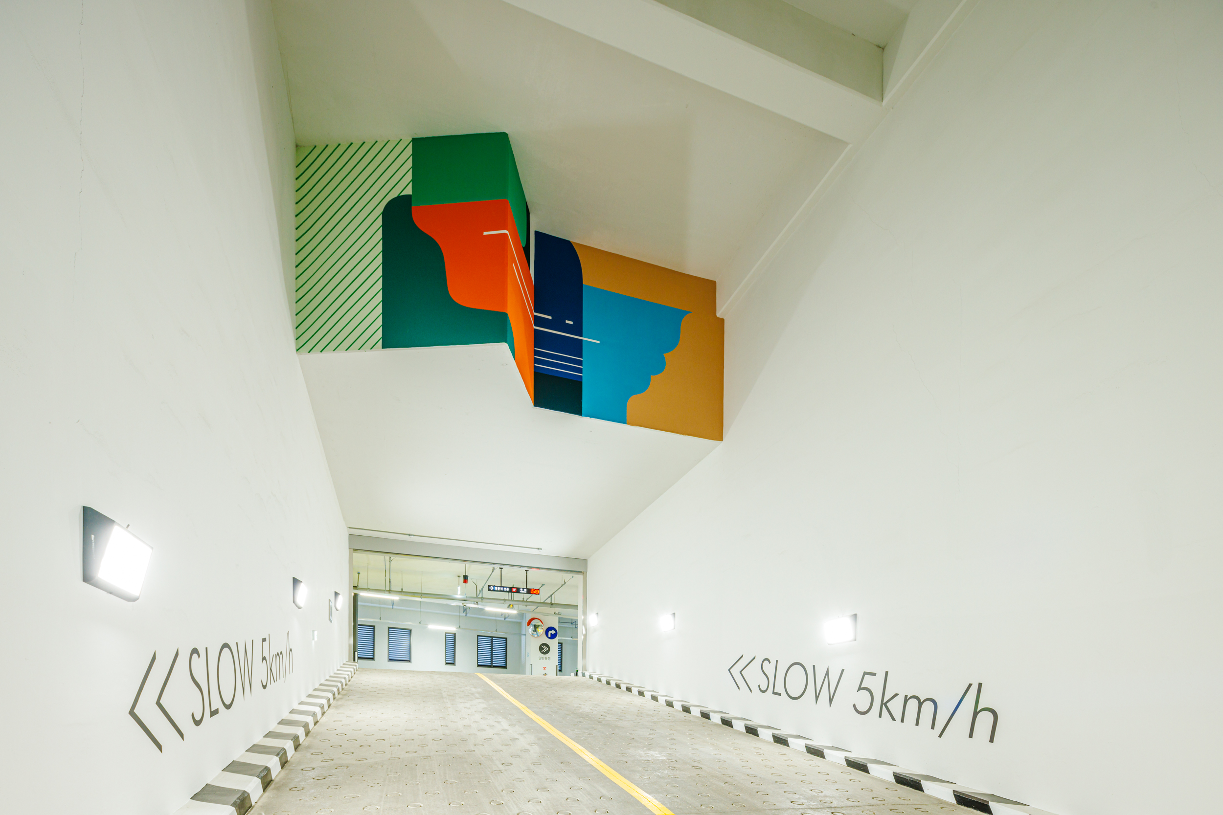 A colorful art wall in collaboration with Junkhouse is installed on the wall in front of the underground parking lot