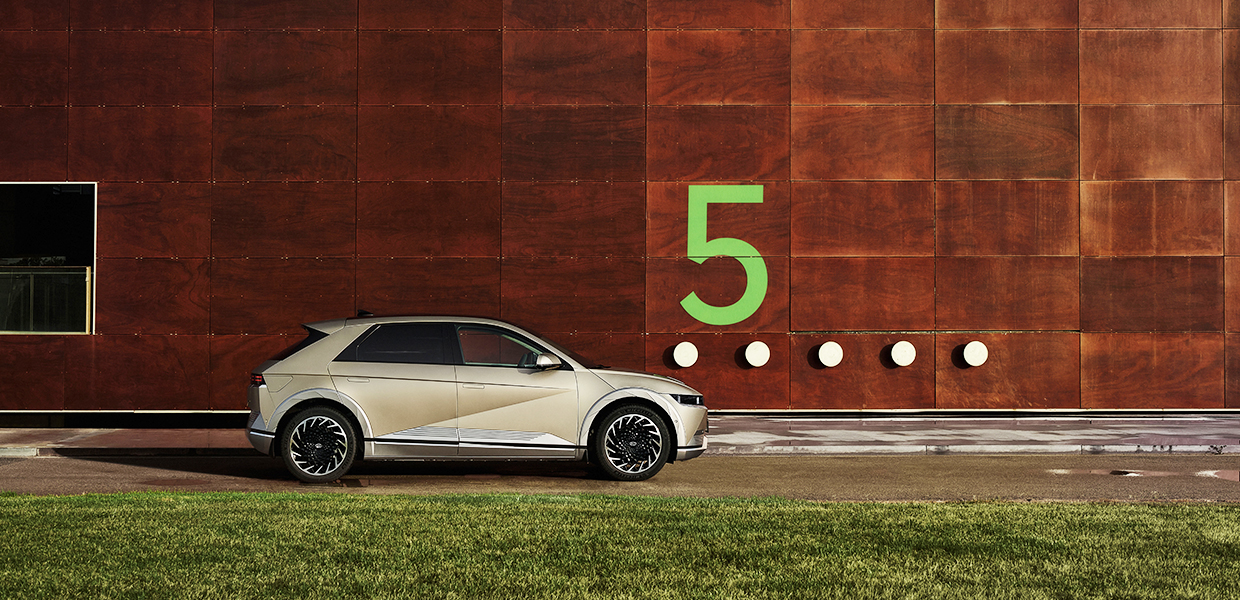 숫자 5가 새겨진 벽을 배경으로 서 있는 현대차 아이오닉 5의 모습