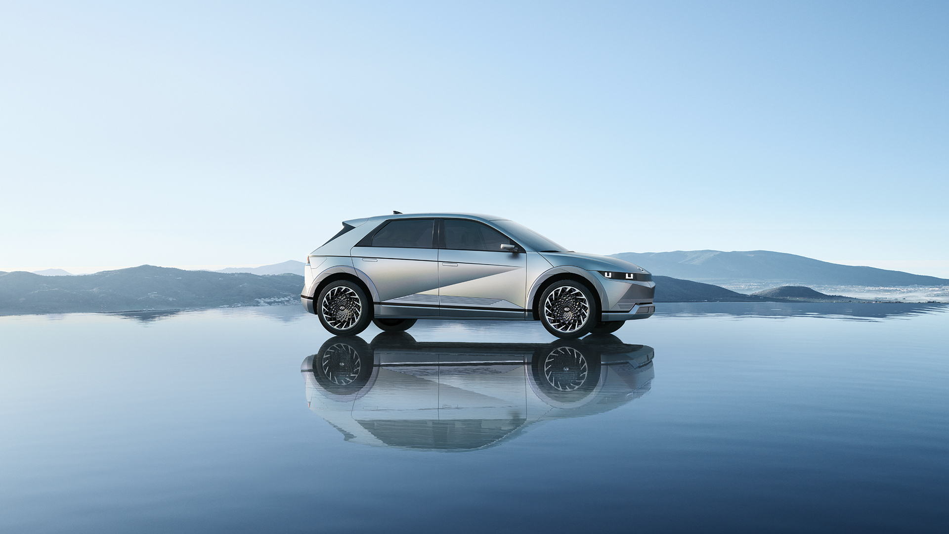 하늘과 잔잔한 호수가 돋보이는 곳에서 아이오닉 5가 수면 위에 서 있다