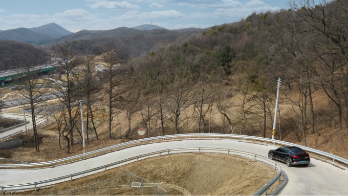 GV60 going down a winding road in a small mountain