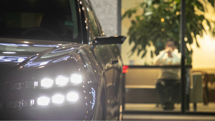 Six headlamps arranged in two rows of three are shining brightly