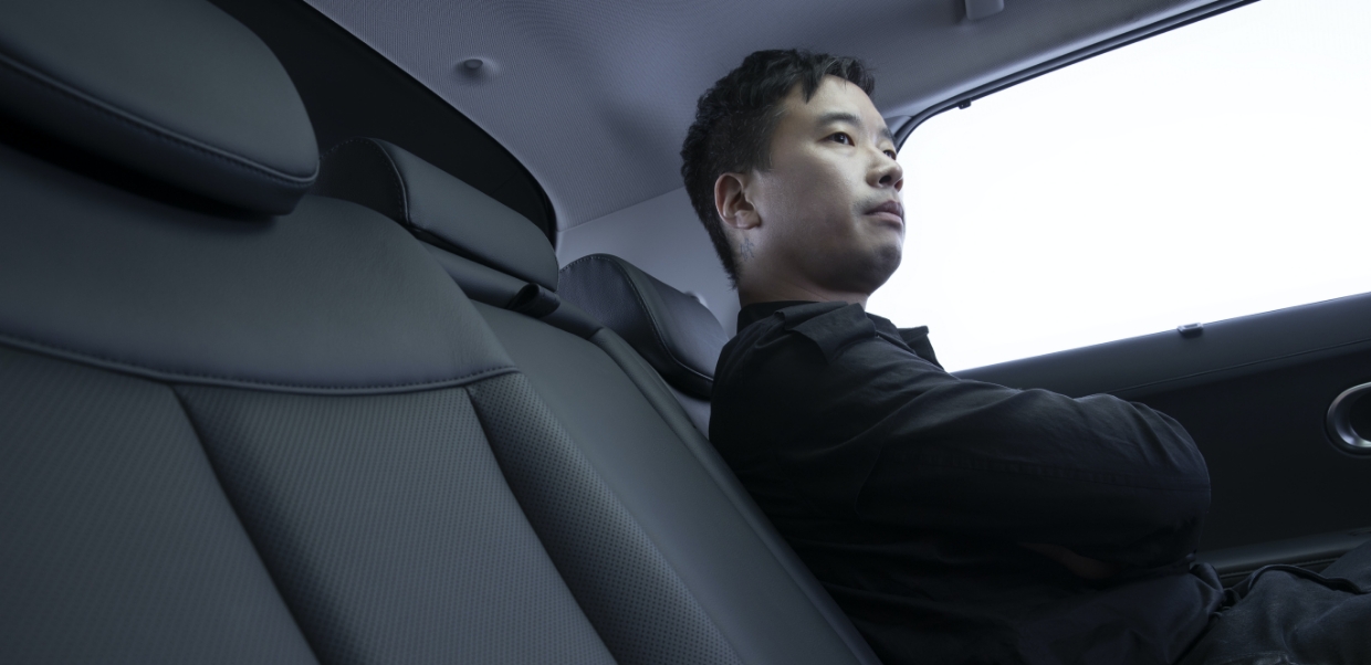 음악감독 정재일이 아이오닉5 뒷좌석에 앉아 앞을 응시하는 모습