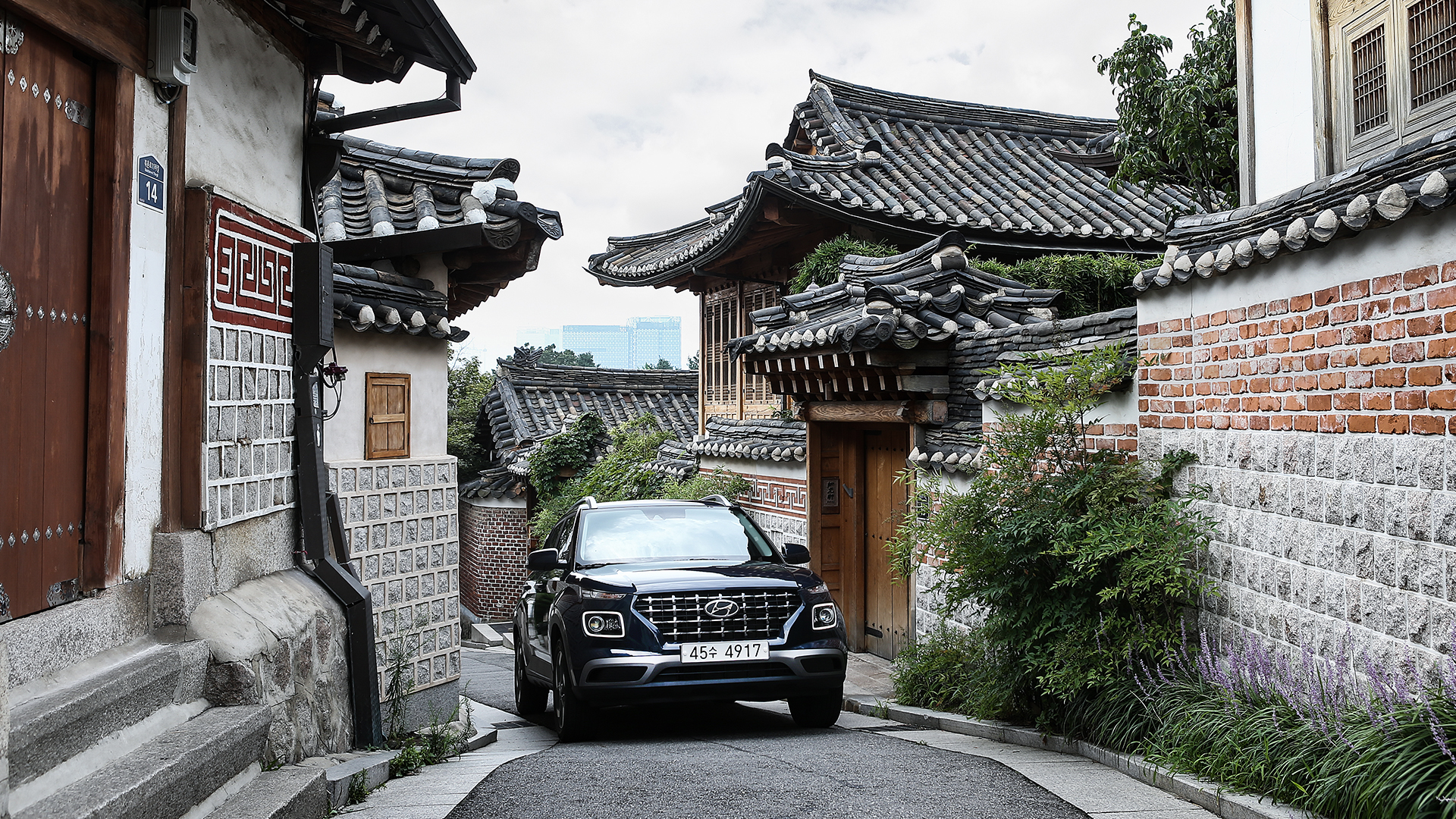 Hyundai Motor Venue is walking down an alleyway in a residential area