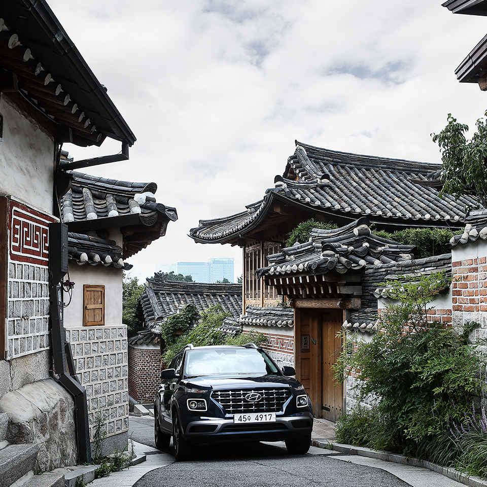 Hyundai Motor Venue is walking down an alleyway in a residential area