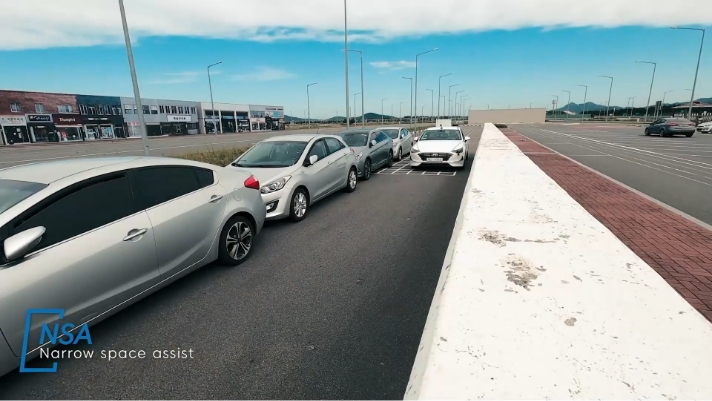 Cars driving on a narrow road with vehicles stopped in a line