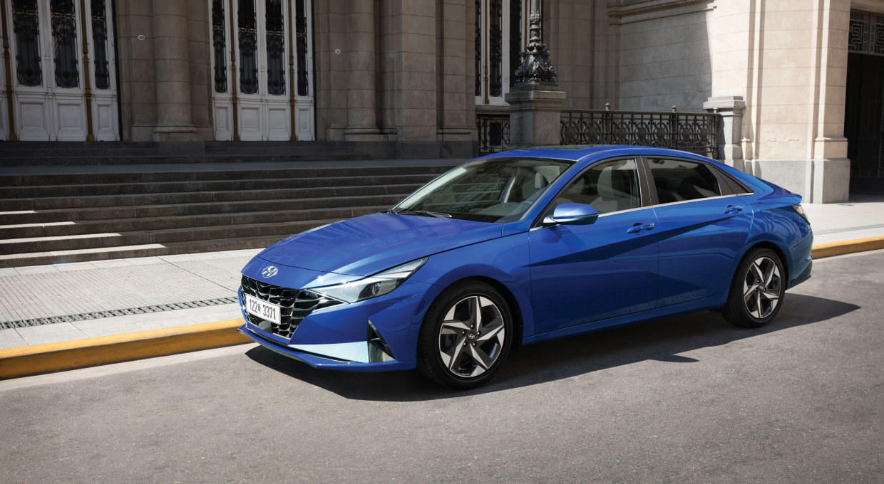 건물 앞에 주차되어 있는 아반떼 전측면부 모습