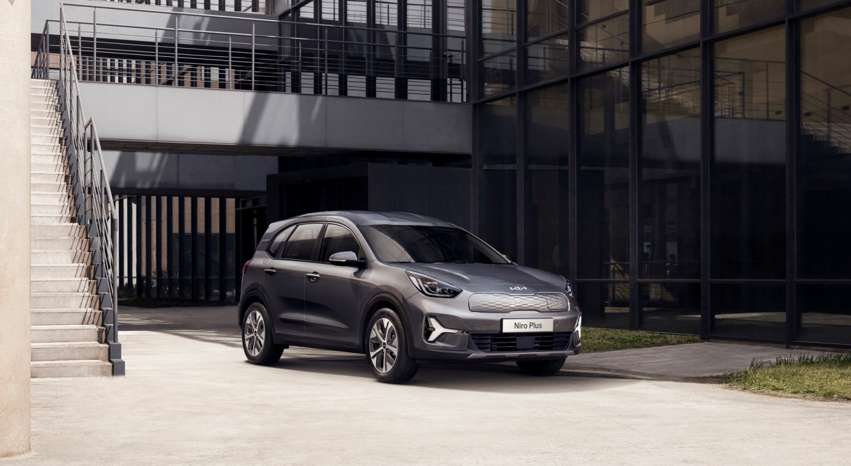 건물 앞에 주차되어 있는 기아 니로 플러스 개인·법인 모델의 전측면부