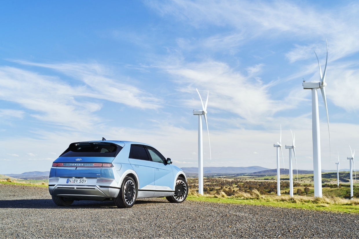 Hyundai Motor Company's eco-friendly electric car Ioniq 5 stands facing the wind power plant