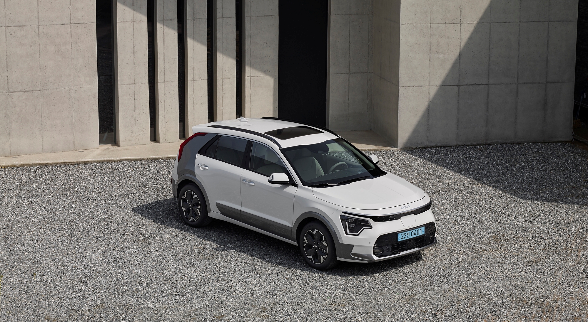 회색 건물 앞에 주차되어 있는 신형 니로 EV 전측면부