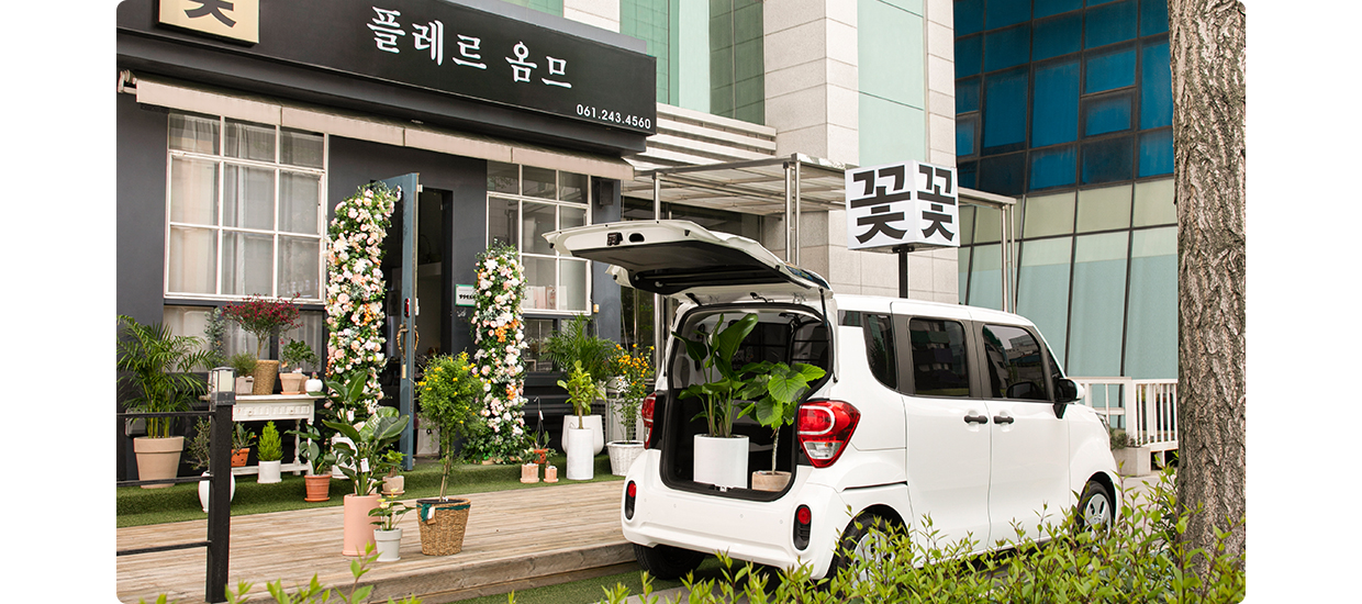 꽃집 앞에 레이 밴이 테일게이트를 연채 서있는 모습