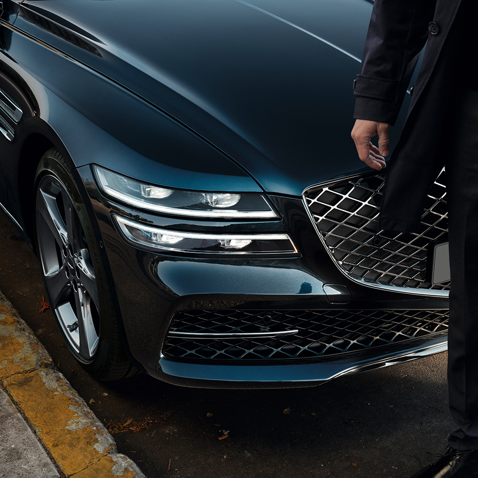 a person is standing in front of the Genesis G80