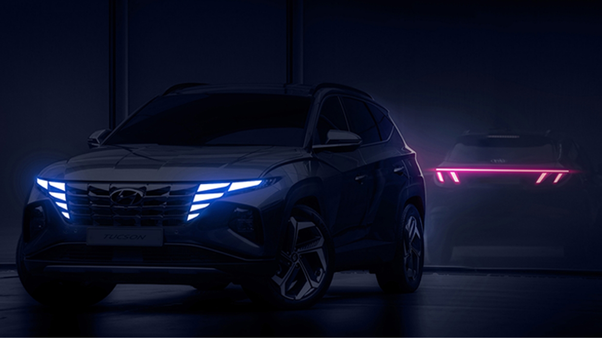 Hyundai Tucson is standing in a dark place with the headlights and tail lights on