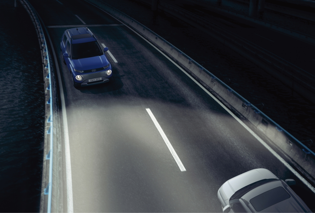 A car with its high beams on is crossing an oncoming vehicle