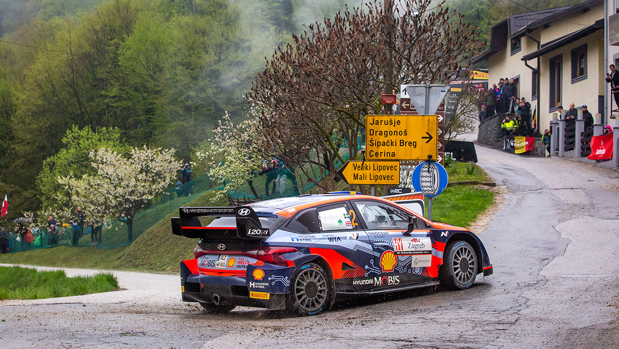 Hyundai i20 N WRC Rally 1 running at high speed on a narrow street in town