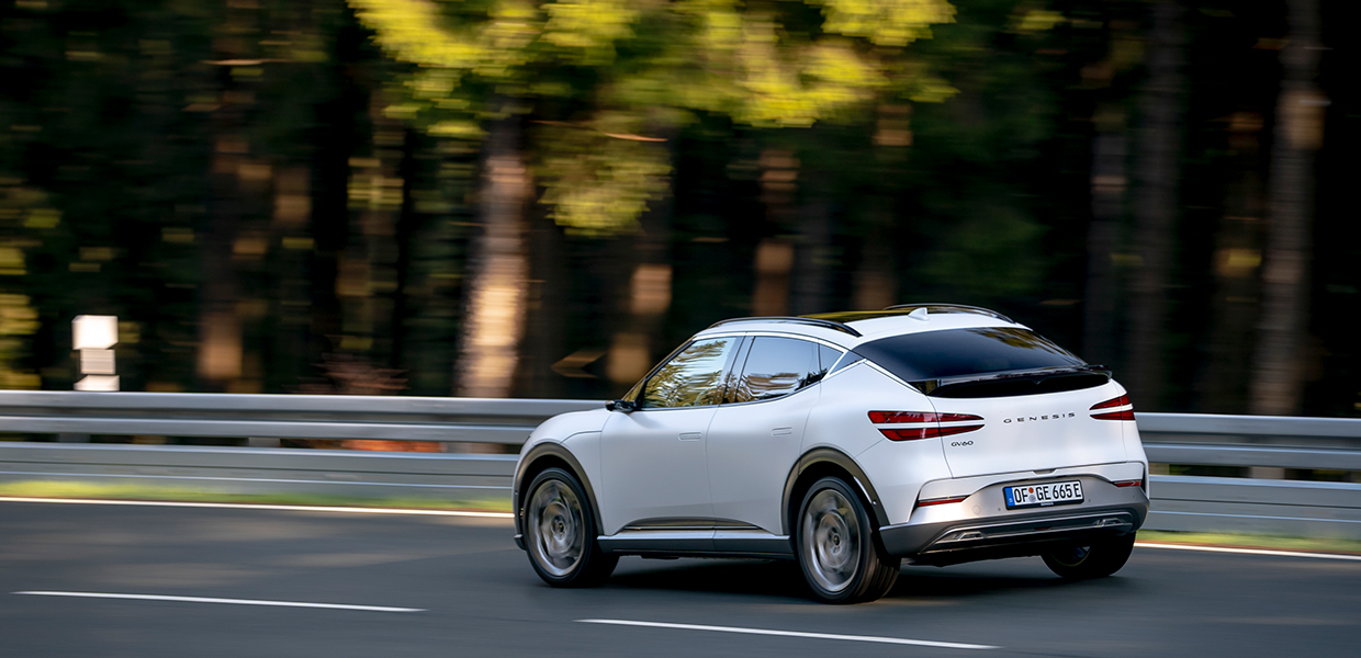 유럽의 어느 길을 질주 중인 제네시스 GV60의 후측면 모습