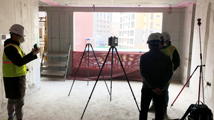 현대건설이 3차원 레이저 스캐너로 바닥을 측정하는 모습