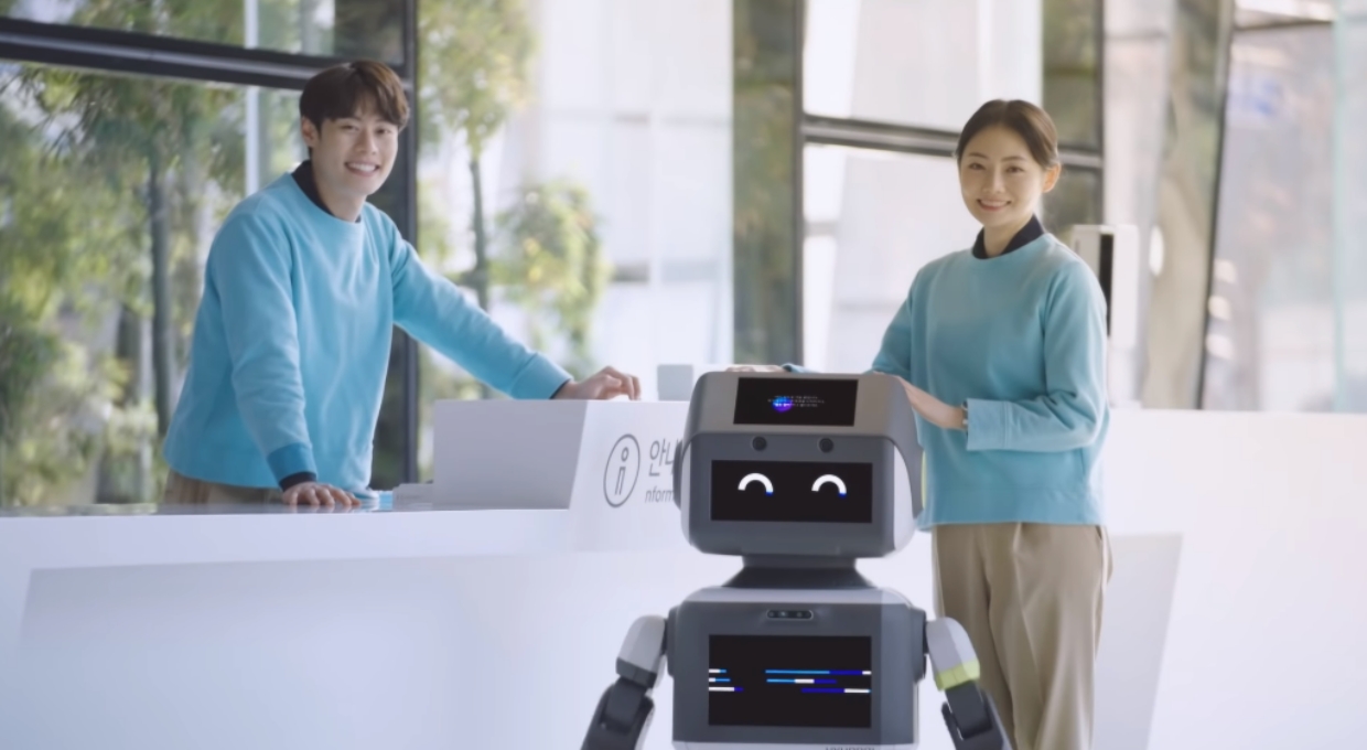 남자와 여자, 그리고 웃고 있는 로봇 DAL-e의 모습