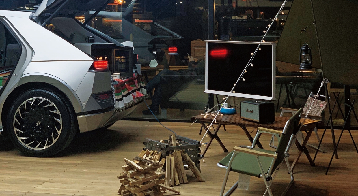 트렁크가 열린 아이오닉 5 후면부와 캠핑용품이 모여 있는 모습