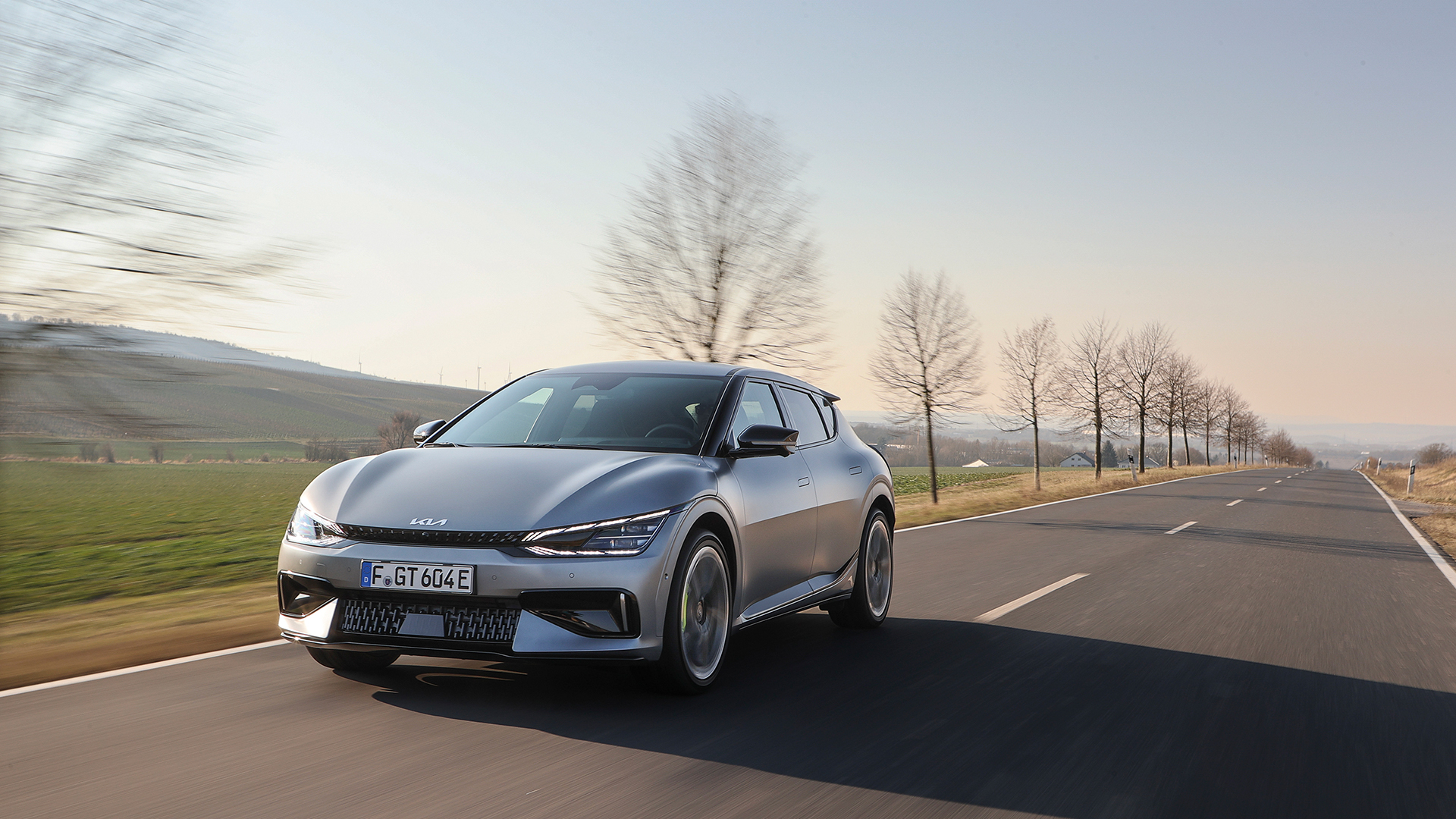 A view of the Kia EV6 GT driving down a European suburban road