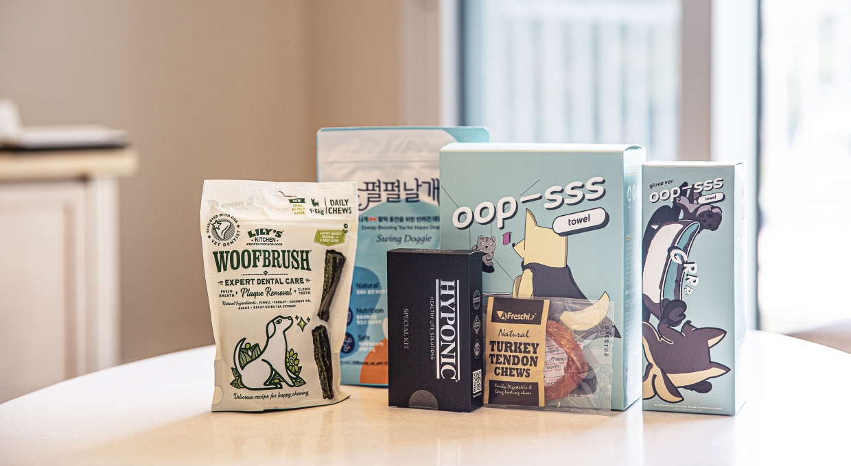 테이블 위에 놓인 강아지 전용 치석 제거 간식과 배변 봉투 등 반려견 전용 어메니티