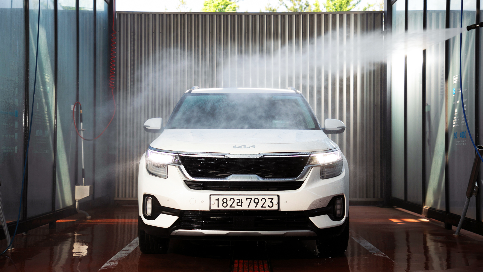 셀프 세차장 부스에서 기아 셀토스를 세차하고 있다