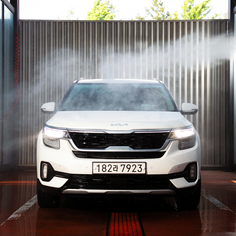 셀프 세차장 부스에서 기아 셀토스를 세차하고 있다