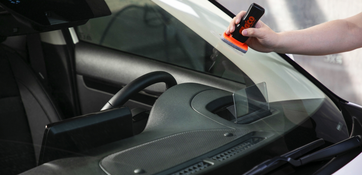 스틱형 유막 제거제로 앞 유리를 닦아내고 있다