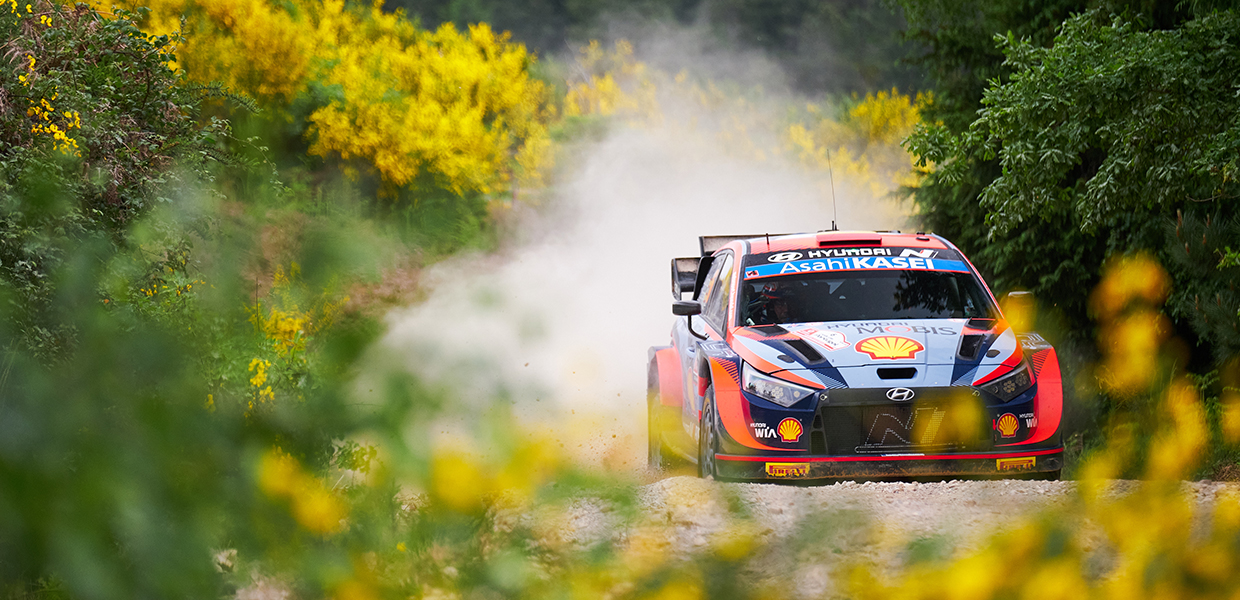 The i20 rally car is driving down the mountain road